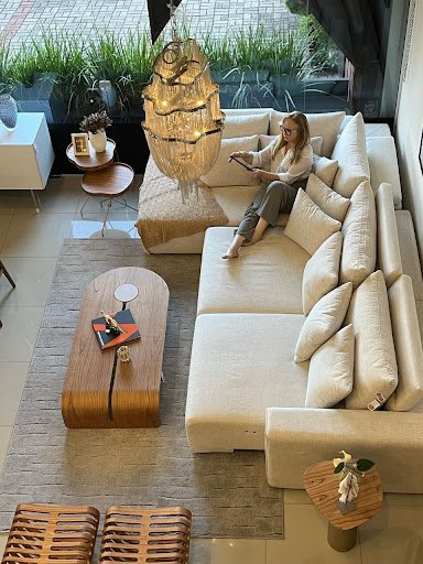 sala de estar com sofá, mesa de centro, mesas laterais, tapete, bancos e almofadas da loja Decore Bem Móveis em Novo Hamburgo