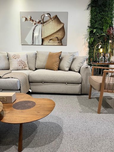 Sala de estar com sofá, mesa de centro, almofadas, poltronas, tapetes e decorações vendidas pela loja Decore Bem Móveis em Novo Hamburgo